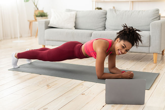 Woman exercising at home taking an online class